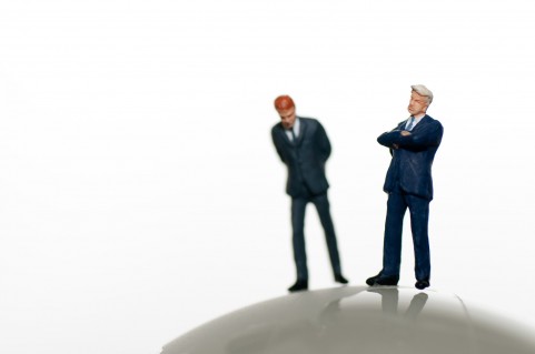 腕を組む二つのビジネスマン人形